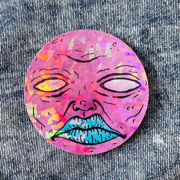 Pink moon face on holographic sticker vinyl with a gloss finish that is waterproof, UV-resistant, and able to withstand excessive handling. From Osseous Design by independent artist Makena Peet.