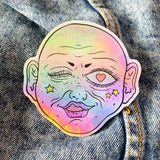 Funky pink face on holographic sticker vinyl with a gloss finish that is waterproof, UV-resistant, and able to withstand excessive handling. From Osseous Design by independent artist Makena Peet.